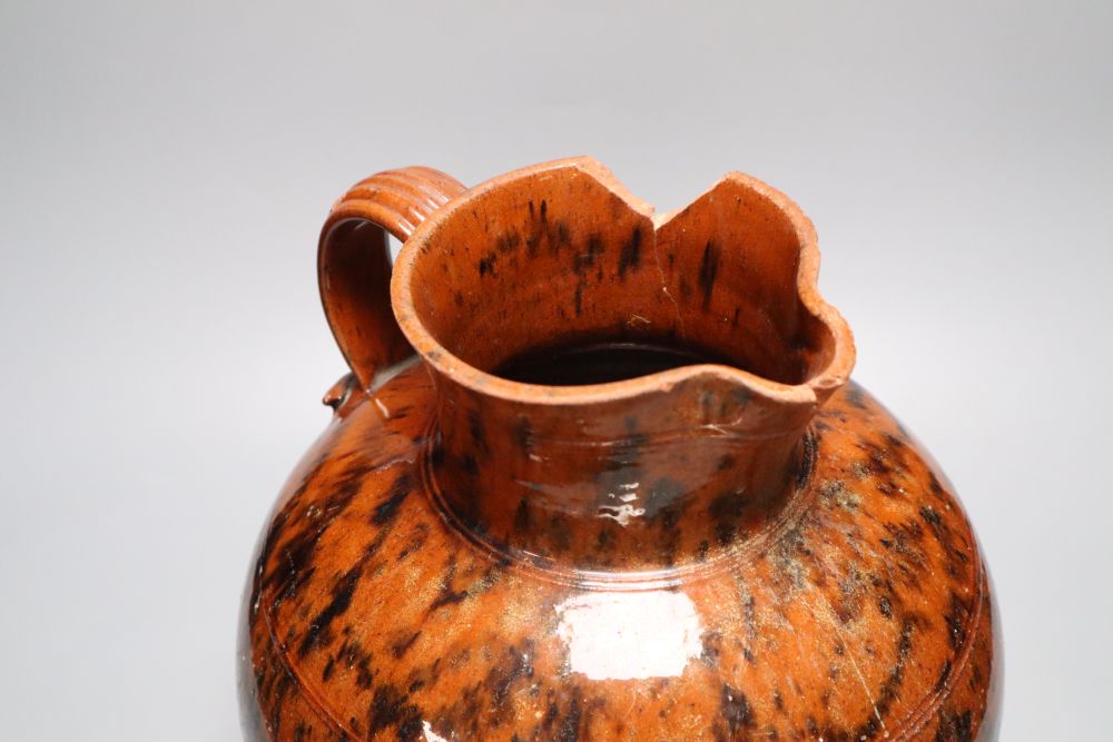 A 19th century Sussex terracotta jug, with black striped glaze, height 30cm (a.f.)